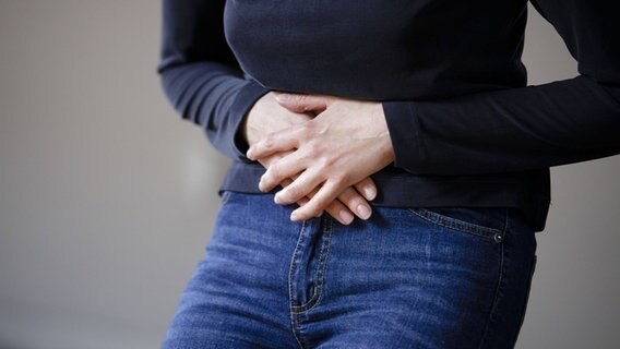 Eine Frau hält sich den Bauch. © Imago 