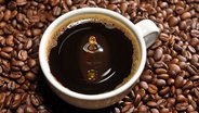 Eine Tasse Kaffee vor Kaffeebohnen © Colourbox 