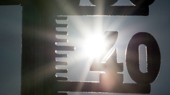 Die Sonne scheint hinter einem Thermometer mit der 40 Grad Anzeige. © Picture Alliance/dpa Foto: Patrick Seeger