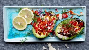 Two avocado halves with dill cream cheese lie on a plate.  © NDR Photo: Claudia Timmann