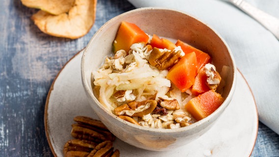 Eine Schüssel Birchermüsli mit Papaya steht auf dem Tisch. © NDR Foto: Claudia Timmann