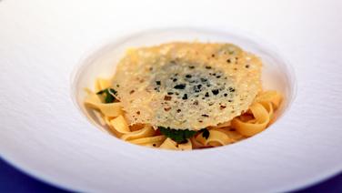 Hausgemachte Bandnudeln mit Zitronen-Vinaigrette und Pecorino-Cracker auf einem tiefen weißen Teller angerichtet. © Thomas Mudersbach / solisTV 