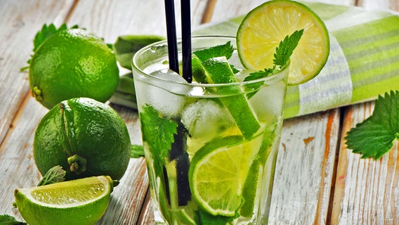 Ein Glas Caipirinha und Limetten auf einem Holztisch. © Fotolia.com Foto: bit24