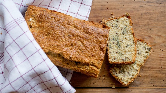 Ein aufgeschnittenes Eiweißbrot liegt auf einem Brett. © NDR Foto: Claudia Timmann