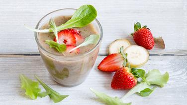 Ein Glas grüner Smoothie mit Erdbeeren steht auf einem Tisch. © NDR Foto: Claudia Timmann