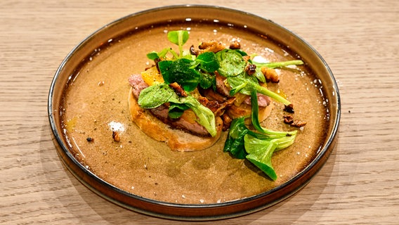 Geröstetes Baguette mit Entenbrust, Orangen-Filets und Feldsalat auf einem Teller angerichtet. © NDR/Fernsehmacher GmbH Foto: Markus Hertrich