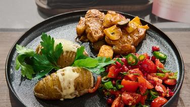 BBQ-Schweinefilet mit Fächerkartoffeln und Tomatensalsa auf einem Teller angerichtet. © NDR / Fernsehmacher GmbH Foto: Gunnar Nicolaus