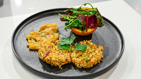 Hirsebratlinge mit Mango-Senf-Chutney und fruchtigem Salat auf einem Teller angerichtet. © NDR / Fernsehmacher GmbH Foto: Markus Hertrich