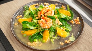 Chili-Garnelen mit Feldsalat, Orangen und Walnuss-Dressing auf einem Teller angerichtet. © NDR / Die Fernsehmacher Foto: Norman Kalle