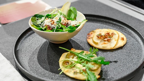 Süß und herzhaft: Zweierlei Flammkuchen mit Feldsalat auf einem Teller angerichtet. © NDR / Fernsehmacher GmbH Foto: Markus Hertrich