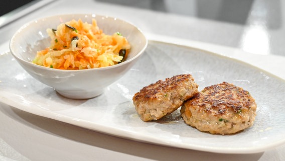 Fleischküchle mit Karotten-Kohlrabi-Salat auf einem Teller angerichtet. © NDR / Fernsehmacher GmbH Foto: Markus Hertrich