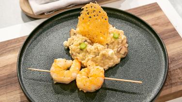 Shrimp skewers and mushroom risotto arranged on a plate.  © Fernsehmacher GmbH & Co.  KG Photo: Norman Kalle