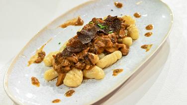 Selbst gemachte Gnocchi mit Pilzrahm und Trüffel auf einem Teller angerichtet. © NDR / Die Fernsehmacher Foto: Markus Hertrich