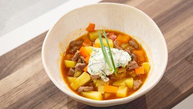 Gulaschsuppe mit Creme Fraiche in einer Schale angerichtet. © NDR / Fernsehmacher GmbH Foto: Norman Kalle