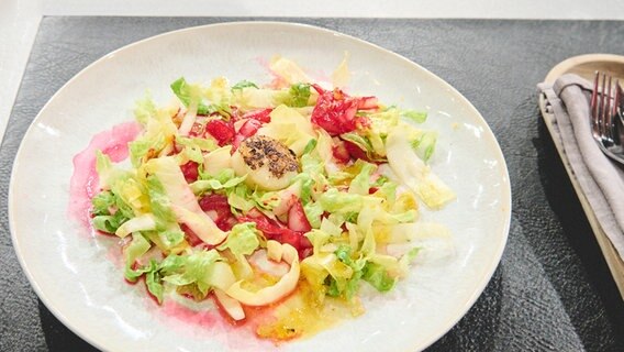 Jakobsmuscheln mit Chicoree-Salat und Orangen-Dressing auf einem Teller angerichtet. © NDR / Fernsehmacher GmbH Foto: Gunnar Nicolaus