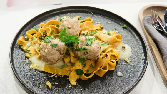 Königsberger Klopse mit Kurkuma-Tagliatelle auf einem Teller angerichtet. © NDR / Fernsehmacher GmbH Foto: Gunnar Nicolaus