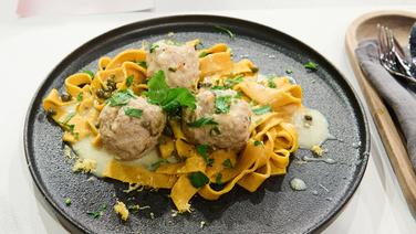 Königsberger Klopse are served on a plate with turmeric tagliatelle.  © NDR / Fernsehmacher GmbH Photo: Gunnar Nicolaus