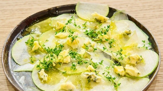 Kohlrabi-Carpaccio mit Birne und Blauschimmelkäse auf einem Teller angerichtet. © NDR / Fernsehmacher GmbH Foto: Gunnar Nicolaus