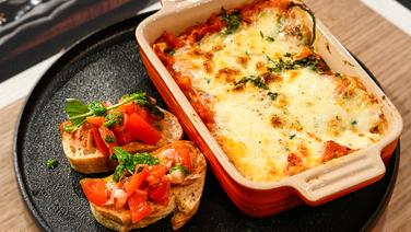 Lasagna with minced cauliflower and pesto bruschetta served on a plate.  © NDR/Fernsehmacher GmbH Photo: Markus Hertrich