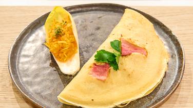 Pfannkuchen mit Pfifferlingen und Möhrensalat im Chicoréeblatt auf einem Teller angerichtet. © Fernsehmacher GmbH & Co. KG Foto: Gunnar Nicolaus
