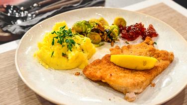 Putenschnitzel  "Wiener Art" mit Kartoffel-Steckrüben-Stampf und Kohlsprossen auf einem Teller angerichtet. © NDR/Fernsehmacher GmbH Foto: Markus Hertrich