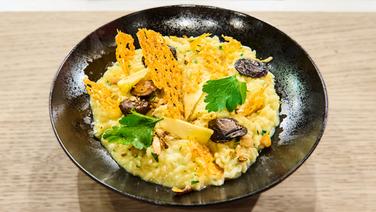 Risotto mit Kräuterseitlingen und Parmesanchip auf einem Teller angerichtet. © NDR / Die Fernsehmacher Foto:  Gunnar Nicolaus