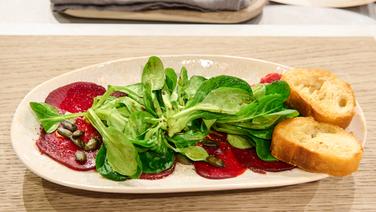 Rote-Bete-Carpaccio auf einem Salatbett auf einem Teller angerichtet. © Fernsehmacher GmbH & Co. KG Foto: Gunnar Nicolaus