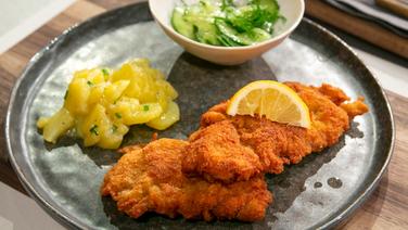 Wiener Schnitzel mit Kartoffel- und Gurkensalat auf einem Teller angerichtet. © Fernsehmacher GmbH & Co. KG Foto: Norman Kalle