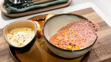 Birnen-Sellerie-Suppe mit Korallenchip auf einem Teller angerichtet. © Fernsehmacher GmbH & Co. KG Foto: Norman Kalle