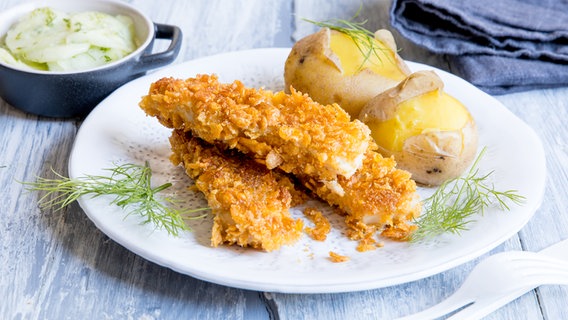 Ein Teller mit Fischstäbchen und Pellkartoffeln steht auf dem Tisch. © NDR Foto: Claudia Timmann