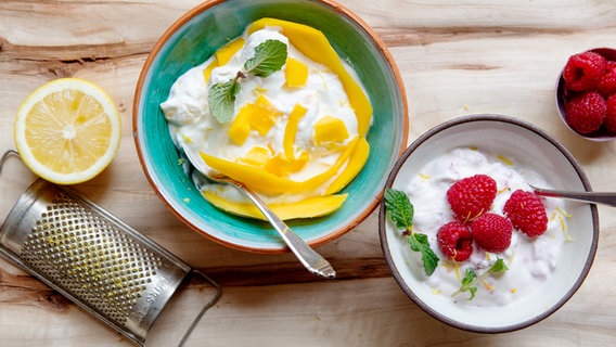 Zwei Schüsseln Fruchtquark mit Mango und Himbeeren auf einem Tisch. © NDR Foto: Claudia Timmann