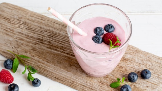 Ein Glas mit Beeren-Fruchtshake steht auf einem Brett. © NDR Foto: Claudia Timmann