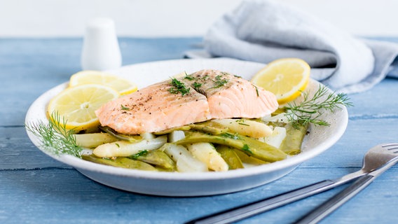 Ein Teller mit gedünstetem Lachs und Gemüse steht auf dem Tisch. © NDR Foto: Claudia Timmann