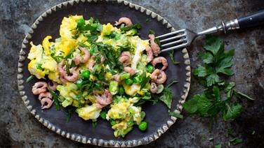 A plate of scrambled eggs with shrimp is on the table.  © NDR Photo: Claudia Timmann