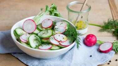 Gurken-Radieschen-Salat in einer Schüssel auf einem Holzbrett. © NDR Foto: Claudia Timmann