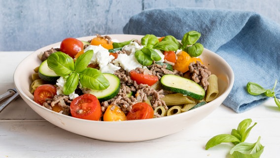 Ein Teller mit Huelsenfrüchte-Pasta mit Zucchini, Hack und Feta steht auf dem Tisch. © NDR Foto: Claudia Timmann