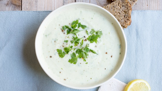 Eine Portion helle Suppe mit Kräutern, von oben betrachtet. © NDR Foto: Claudia Timmann