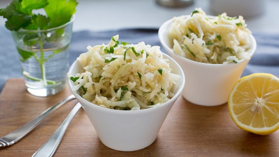 Zwei Schüsseln mit Kohlrabisalat stehen auf einem Holzbrett. © NDR Foto: Claudia Timmann