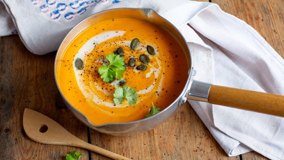 Ein Topf mit Kürbissuppe steht auf einem Tisch. © NDR Foto: Claudia Timmann