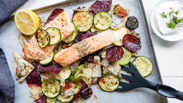 A tray with salmon fillet on baked vegetables is on the table.  © NDR Photo: Claudia Timmann