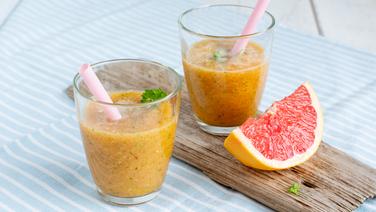 Mango-Petersilie-Smoothie in zwei Gläsern und ein Stück Grapefruit auf einem Brett. © NDR Foto: Claudia Timmann