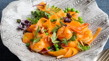 Carrot tagliatelle served with prawns on a plate.  © NDR Photo: Claudia Timmann