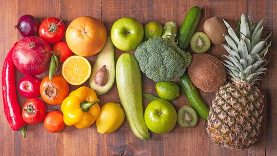 Verschiedene frische Obst- und Gemüsesorten liegen auf einem Holzbrett. © Colourbox 