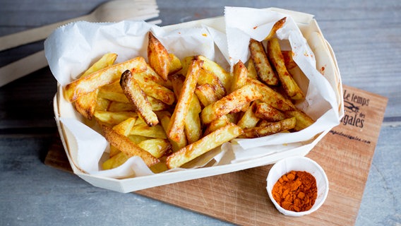 Ein Schälchen Pommes steht auf einem Holzbrett. © NDR Foto: Claudia Timmann