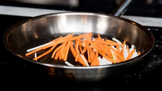 Lauch- und Karottenstreifen garen in einer Pfanne. © NDR Foto: Claudia Timmann