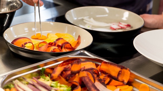 Dünn geschnittene Gemüsesorten werden auf einem Teller mariniert. © NDR Foto: Claudia Timmann