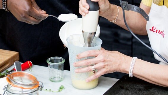 Joghurt wird ein einem hohen Gefäß mit einem Stabmixer verrührt. © NDR Foto: Claudia Timmann