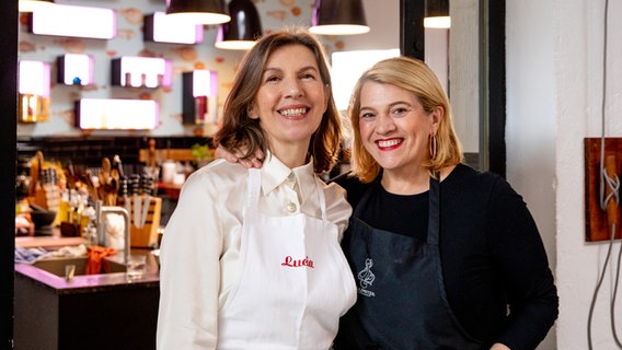 Sterneköchin Léa Linster und NDR Reporterin Lucia Baumgärtner stehen in einer Küche. © NDR Foto: Claudia Timmann