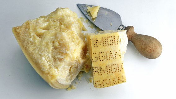 Ein geteiltes Stück Parmesankäse und ein Parmesan-Messer. © picture-alliance/dpa/Stockfood Foto: FoodPhotography Eising