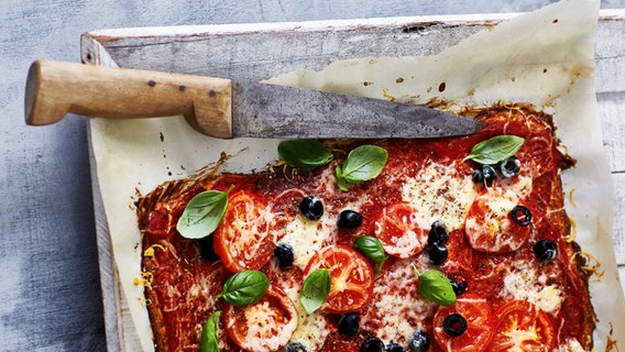 Pizza mit Tomaten auf einem Backblech. © Gräfe und Unzer Foto: Monika Schürle und Maria Grossmann